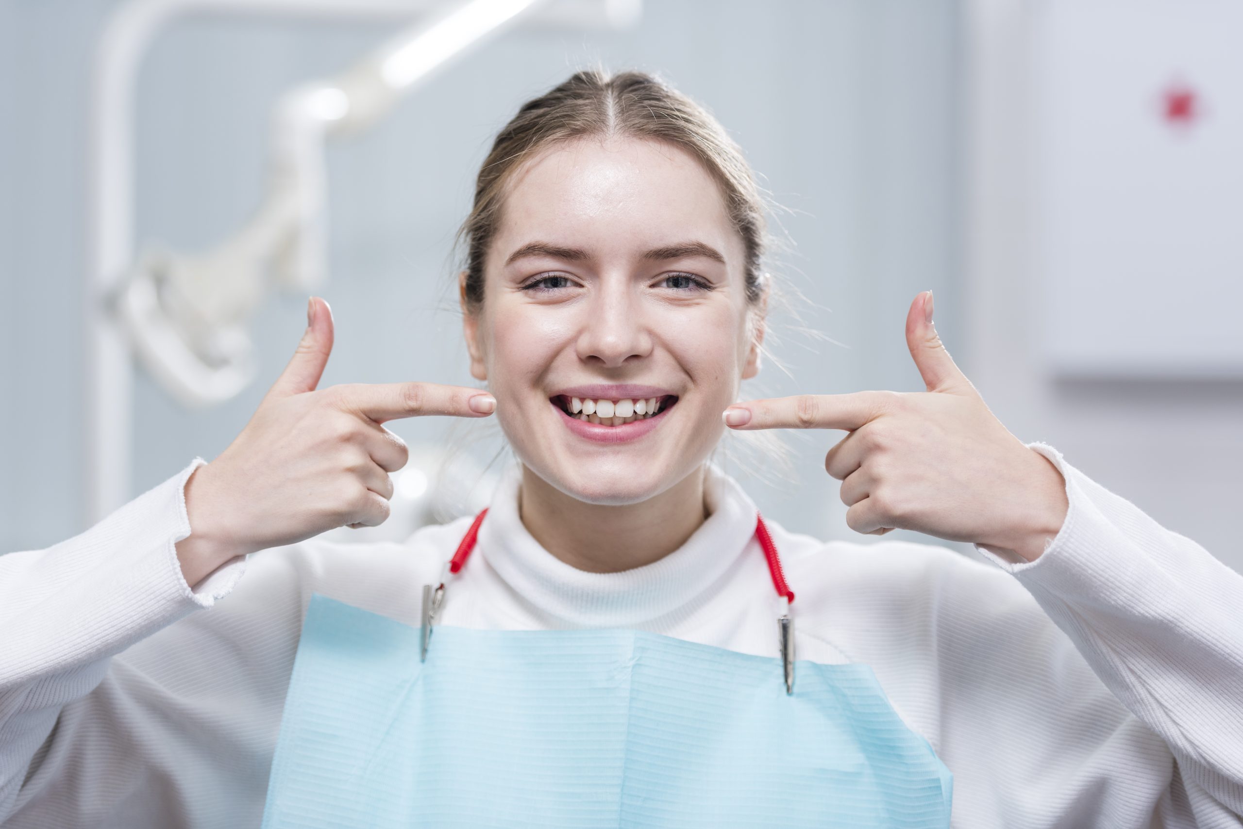 a woman smiling with her fingers to her face