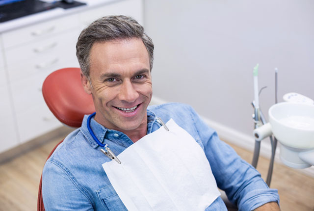 a man sitting in a chair with a medical mask attached to his neck